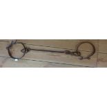 An antique set of two wrought iron slave neck collars connected by a bar