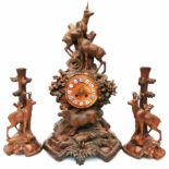 A late 19th Century Black Forest garniture, the clock depicting mountain goats and edelweiss on rock