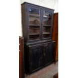 A 3' 5 1/2" stained wood two part book cabinet with glazed panel doors to top and panelled