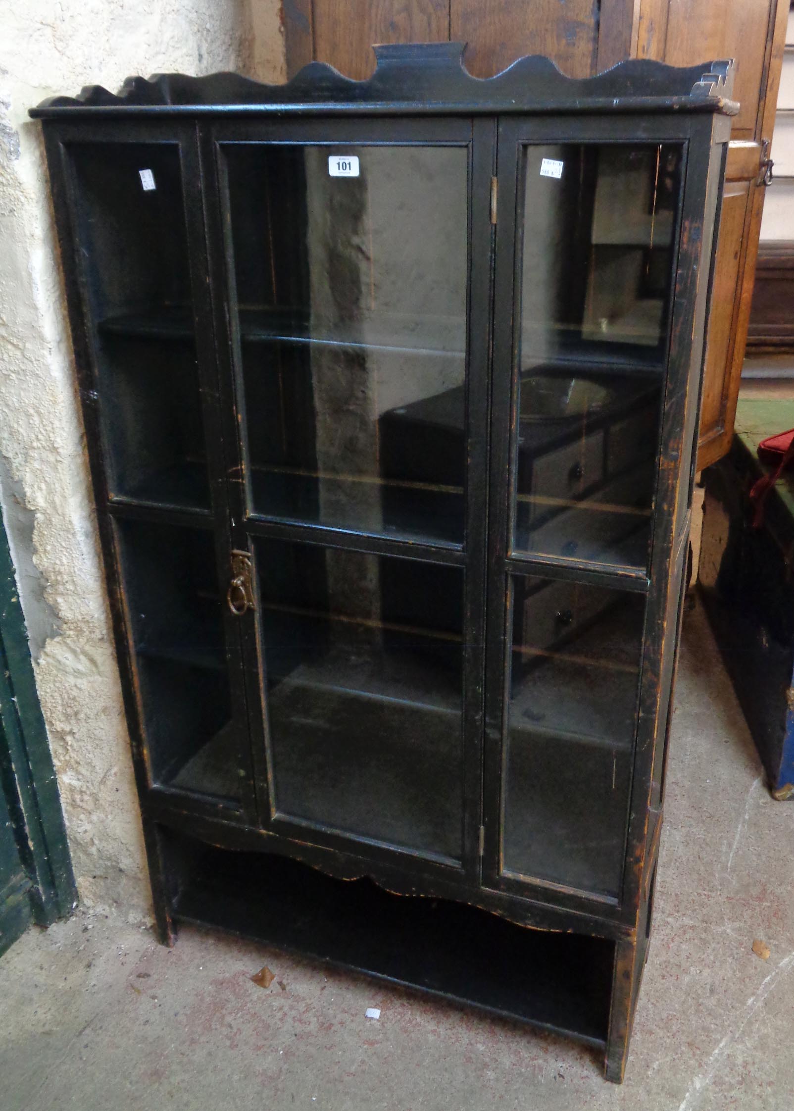 A 34" early 20th Century stained wood book cabinet with four shelves enclosed by a glazed panel door