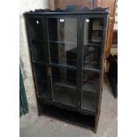 A 34" early 20th Century stained wood book cabinet with four shelves enclosed by a glazed panel door