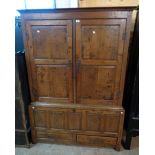 A 4' 6" antique polished oak two part cabinet with shelves enclosed by a pair of fielded panelled