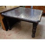 A late Victorian ebonised oak extending dining table with moulded edge, canted corners and single