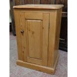 An 18 1/2" waxed pine bedside pot cupboard with panelled door and moulded base