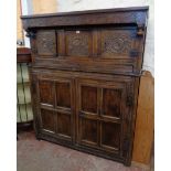 A 4' 6 3/4" antique polished oak livery cupboard with blind fretwork scroll decoration, flanking