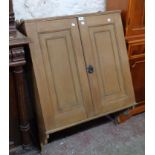 A 30 1/2" Victorian waxed pine wall hanging cupboard with shelves enclosed by panelled doors and