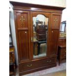 A 4' 9" Edwardian inlaid mahogany wardrobe with hanging space enclosed by a bevelled mirror panel