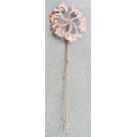A copper flower shaped garden windmill ornament