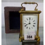 A brass and bevelled glass cased carriage timepiece with original rexine clad travelling case