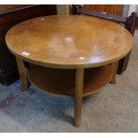 A 34" diameter vintage quarter veneered oak topped two tier tea table with incised decoration and