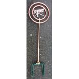 A tubular copper garden sprinkler with two hoops and central dragonfly decoration