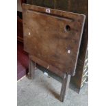 A 23 1/2" old stained pine folding writing table with pen depression and inkwell aperture