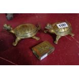 A pair of brass stylized tortoises - sold with a brass matchbox sleeve with arabesque and elephant