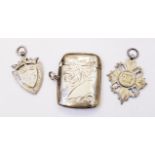 A silver vesta case with engraved decoration - Birmingham 1925 - sold with two silver sporting fobs