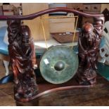 An early 20th Century Chinese carved and stained hardwood immortal figural stand with 8" diameter