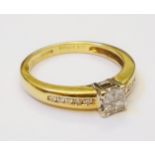 An imported 750 yellow metal ring, set with four paved diamonds and further channel set diamonds