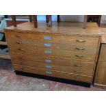 A 4' 3" vintage polished oak two part plan chest with six drawers and ebonised plinth base