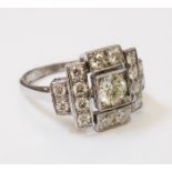 A marked 18ct. white metal Art Deco style ring, set with central diamond and further small