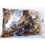 A bag containing a large quantity of assorted costume jewellery