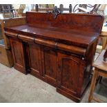 A 5' Victorian flame mahogany sideboard with low raised back and three cushion shaped frieze drawers
