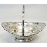 A 9" silver cake basket with swing handle, pierced and engraved decoration, set on raised foot -
