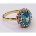 A marked 18ct. and Plat ring, set with central oval pale blue zircon within a diamond encrusted