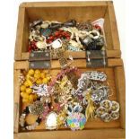 A wooden box containing costume jewellery brooches and other items