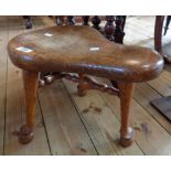 A 19th Century polished oak saddle shaped stool, set on triple turned legs and stretchers