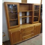 A 5' 1 1/2" late 20th Century Ercol light elm sideboard with two open shelves and flanking glazed