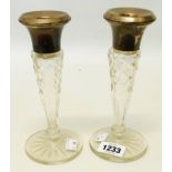 A pair of 7 3/4" cut glass candlesticks with silver nozzles