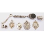 Four white metal sporting fobs - sold with a part swivel fob, thimble, four studs and salt spoon