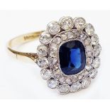 A marked '18ct. gold' diamond encrusted oval panel ring, set with central sapphire