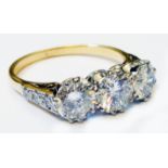 A marked 18ct. yellow metal ring, set with three central diamonds and further small diamonds to