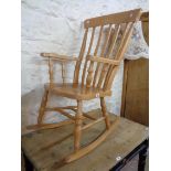 A modern polished beech high lath back rocking chair with solid sectional seat, set on turned
