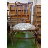 An early 20th Century stained beech framed boudoir elbow chair, set on slender cabriole front