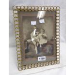 A vintage brass picture frame of chain link design