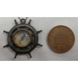 A miniature compass in the form of a ship's wheel