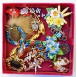 A box containing sixteen assorted costume jewellery brooches