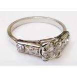 A white metal ring, set with central round cut diamond and six paved diamonds to shoulders - main