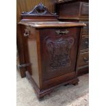A 16 1/2" Edwardian walnut coal perdonium with low raised back, serpentine top and carved decoration