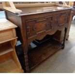 A 3' 6" early 20th Century stained oak dresser base with two Jacobean style frieze drawers, shaped