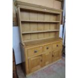 A 5' 2" Victorian waxed pine two part dresser with two shelf open plate rack over a base with