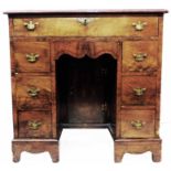 A 29 1/2" Georgian mahogany kneehole desk with long frieze drawer, shaped apron, central recessed