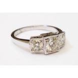 A marked 'Plat' white metal Art Deco style ring with three diamonds in stepped square settings -