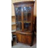 A 35" 20th Century mahogany cross banded and strung bow font corner cabinet in the Georgian style