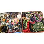Two tins containing a large quantity of assorted costume jewellery, also modern quartz wristwatches