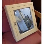 An old painted wood wall mounted medicine cabinet with mirror set door