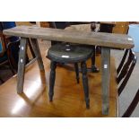 A 35 1/2" old pine trestle stool, set on A-frame supports - sold with a painted wood three leg