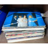 A collection of vinyl LPs including 'Voulez Vous' by ABBA, 'Saturday Night Fever' by The Bee Gees,