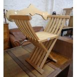A modern Portuguese bleached wood folding X-frame elbow chair with pegged shaped back rail